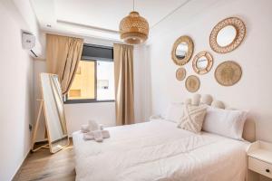 拉巴特TT Holidays Cosy apartment Rabat City Center的卧室配有白色的床和墙上的镜子