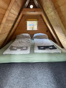 科特布斯Abenteuercamp Schaeferhof Hütten oder Stellplatz für kleinen Camper oder Zelt的小木屋阁楼上的一张床位