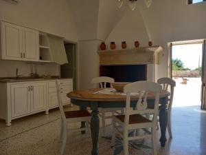 阿卡亚masseria Carlini的厨房配有桌椅和壁炉。