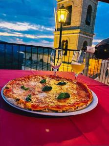 San Martino sulla MarruccinaIl Ghiro 2.0 Casa Vacanze的一张桌子上的比萨饼,上面放着两杯酒