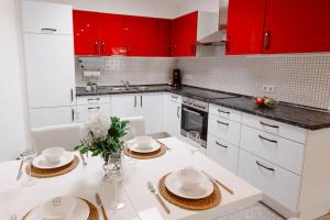 米歇尔施塔特Casa Vivace的厨房配有红色橱柜和白色台面