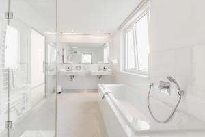 沃尔特湖畔佩莎赫杰丽博士风景酒店的白色的浴室设有浴缸和水槽。