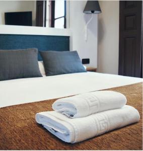 阿尔卡拉德荷那利斯米格尔·德·塞万提斯酒店的白色的床和2条毛巾