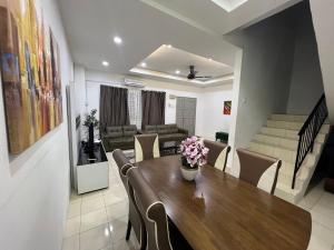 雪邦RUMAH MURNI by IMPIAN HOMESTAY KLIA-SALAK TINGGI-NILAI的用餐室以及带桌椅的起居室。