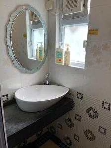 香港芳姐可口渡假屋的浴室设有白色水槽和镜子