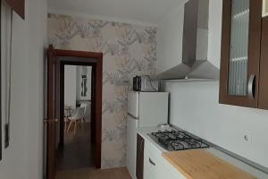韦尔瓦Apartamento Huelva Centro的厨房配有炉灶和白色冰箱。