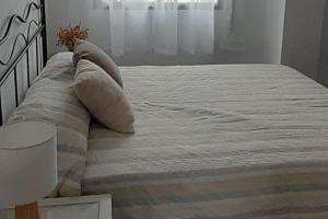 韦尔瓦Apartamento Huelva Centro的一张带白色床单和枕头的床