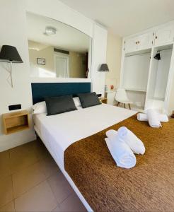 阿尔卡拉德荷那利斯米格尔·德·塞万提斯酒店的一间卧室配有一张带两个白色枕头的大床