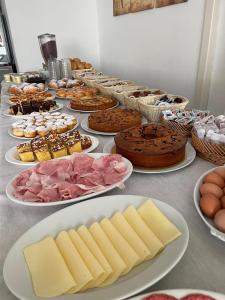 加比切马莱Hotel Tre Stelle Gabicce Mare的一张桌子,上面放着许多不同类型的蛋糕和糕点