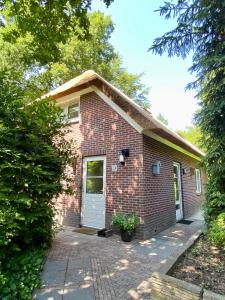 伊皮Huisje aan de Bosrand - Veluwe的砖屋,有白色门