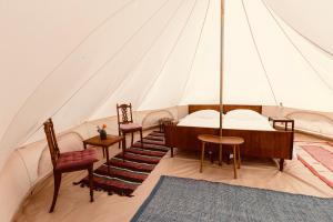 AskebyBygagergaard的带帐篷的客房,配有一张床和椅子