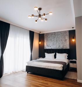 克卢日-纳波卡Pensiunea Brici Junior的一间卧室配有一张大床和一个吊灯。