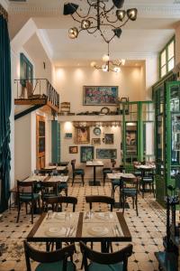 雅典Beautiful City Suites的一间带桌椅和吊灯的餐厅
