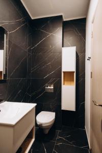 克卢日-纳波卡Pensiunea Brici Junior的浴室设有白色卫生间和黑色墙壁。