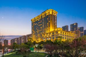 台州台州旗隆万豪酒店的一座高大的黄色建筑,位于城市前方