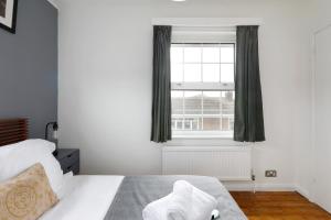罗廷丁Charming 1 bedroom apartment in Rottingdean的卧室配有白色的床和窗户