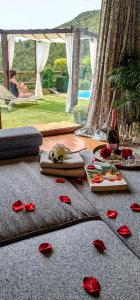 阿尔库什迪瓦尔德维什Love Story - Lareira, Sauna & Piscina的一间玫瑰花铺在地板上的房间和一瓶葡萄酒