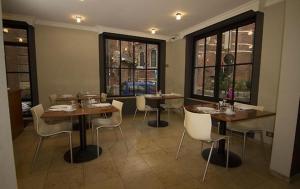 布鲁塞尔Hotel Chantecler的用餐室设有桌椅和窗户。
