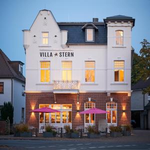 奥尔登堡Villa Stern的前面有紫色雨伞的建筑