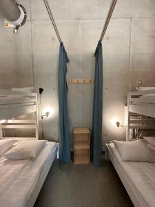 赫尔湾Ohmaria Hotell, del av Ohboy Hotell的蓝色窗帘间内的两张床