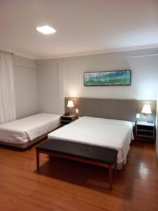 巴乌鲁Biazi Plaza Hotel的酒店客房设有两张床和一台墙上的电视。