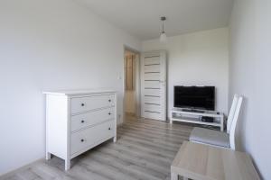 索波特01 Sopot - Apartament mieszkanie dla 6 osób的客厅配有白色梳妆台和电视
