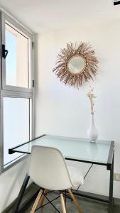布宜诺斯艾利斯Hollywood Suites & Lofts的一张带白色椅子和镜子的玻璃桌