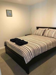 金斯顿Governor Place-Modern Complex的一间卧室,床上有黑色衬衫