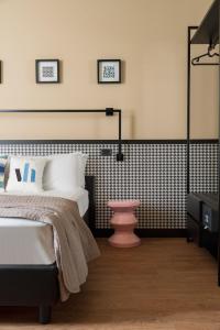 里乔内Hotel Vagabond的一间卧室设有一张床和黑白墙