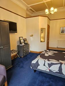 爱丁堡史密斯旅馆的一间卧室配有一张床、梳妆台和电视。