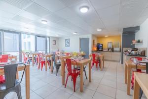 索恩河畔沙隆Appart'City Classic Chalon sur Saone的用餐室配有桌子和红色椅子
