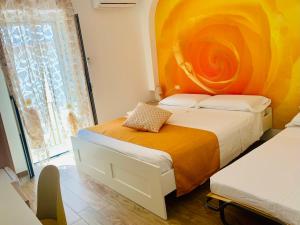 佩斯基奇B&B Di Fiore的一间卧室设有两张带橙色墙壁的床。