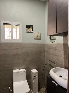 LaminYazmin’s studio apartments的浴室配有白色卫生间和盥洗盆。
