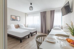 波尔多Appart'City Classic Bordeaux Centre的酒店客房设有两张床和一张桌子。