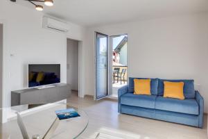巴多利诺Oleandro Holiday Apartments的客厅配有蓝色的沙发和玻璃桌