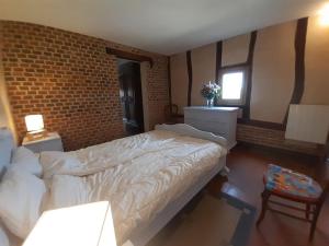 Ligny-le-RibaultLes Hautes Charmante Ferme solognote的一间卧室设有一张床和砖墙