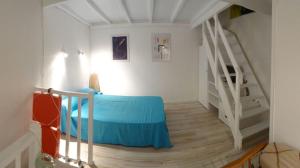 科利尤尔Jetez l'ancre dans notre maison de pêcheur !的一间卧室设有蓝色的床和楼梯。