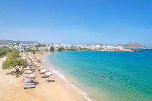 纳乌萨Villa Maria - Naoussa Squares Blue & Gold Suite的海滩上设有椅子和遮阳伞,还有大海