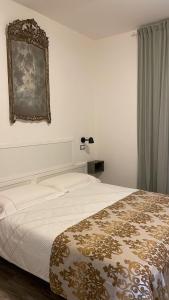 卡拉拉Bilocale Carrara Centro con giardino e parcheggio moto的卧室配有一张床,墙上设有镜子