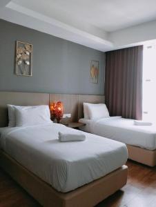 莎阿南Townhouse OAK 591 Shah Alam By Salaam Suites的酒店客房设有两张床和窗户。