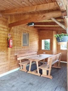 马里亚霍夫Ferienhäuschen in Mariahof的小木屋配有野餐桌和2张长椅