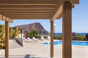 拉特吉塔Home2Book Stylish & Relax Attic La Tejita, Pool的享有度假村游泳池的景色,背景为山脉