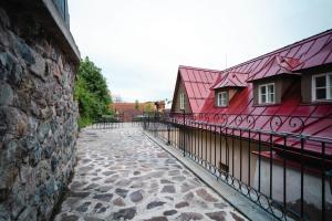 班斯卡 - 什佳夫尼察HoStel Cosmopolitan*的石头人行道旁的红色建筑,有栅栏