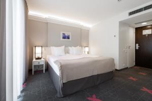 塔林厄米塔格酒店的卧室配有一张带白色床单和枕头的大床。