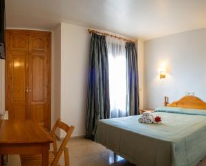 昆卡HOTEL VALMAR的一间卧室配有一张床、一张桌子和一个窗户。