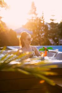 布伦纳库塔尔兹Spa加康体酒店的女人在浴缸里喝着饮料和植物