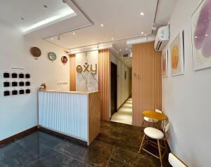 巴淡岛中心Oxy suites 2-02 at Shop House Meisterstadt Pollux Habibie的走廊上,房间里设有柜台和椅子