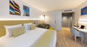马赛Crowne Plaza - Marseille Le Dôme的酒店客房设有一张大床和一张书桌。