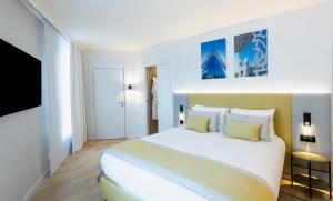 马赛Crowne Plaza - Marseille Le Dôme的卧室配有一张带黄色枕头的大型白色床。