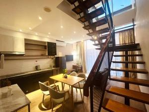巴淡岛中心Oxy suites 2-02 at Shop House Meisterstadt Pollux Habibie的客厅设有楼梯和桌椅